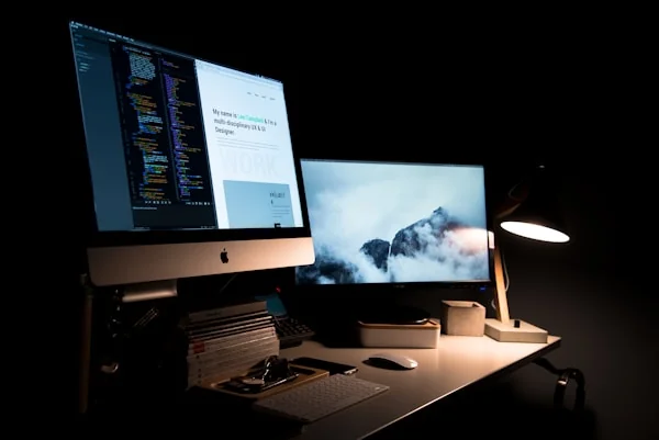 Designer reviewing responsive website mockups on tablet and laptop